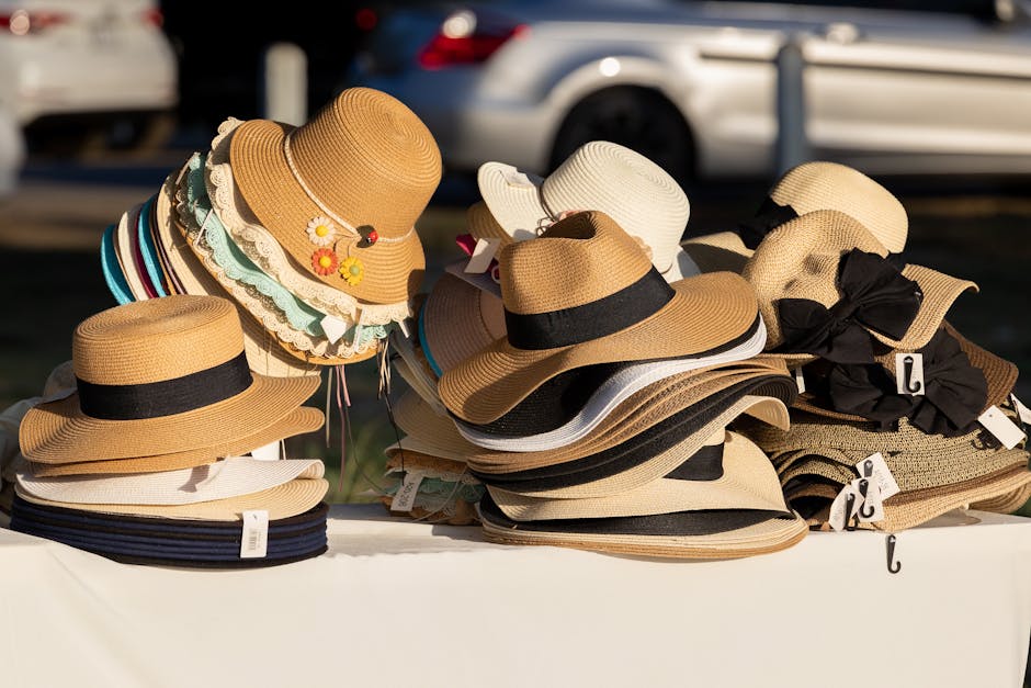 A collection of straw hats on display at an outdoor market stall, capturing sunlight.